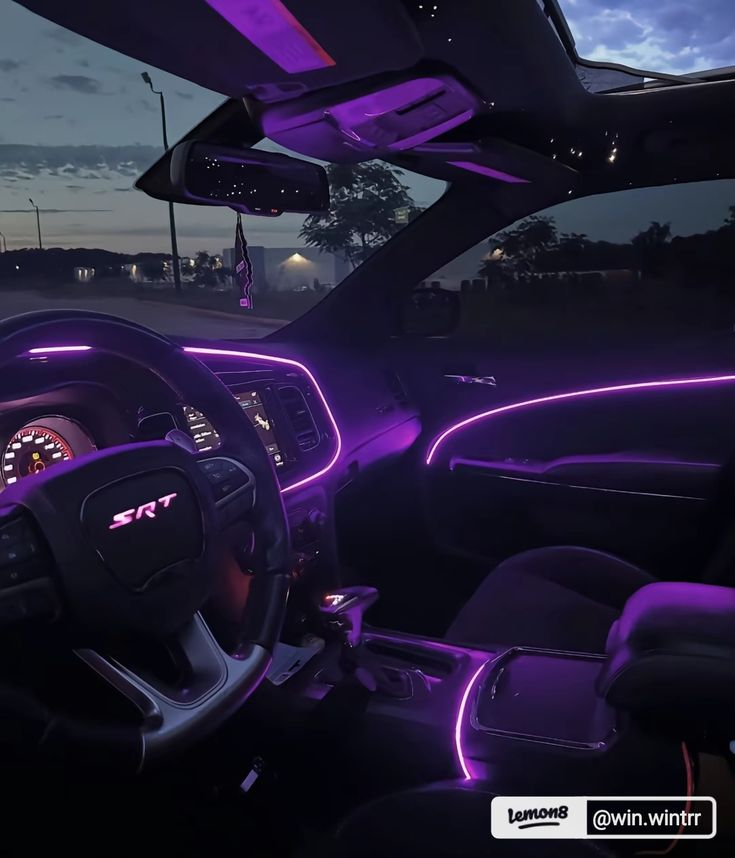 Violet fibre lighting sweeping the dashboard of a Dodge Charger SRT at dusk